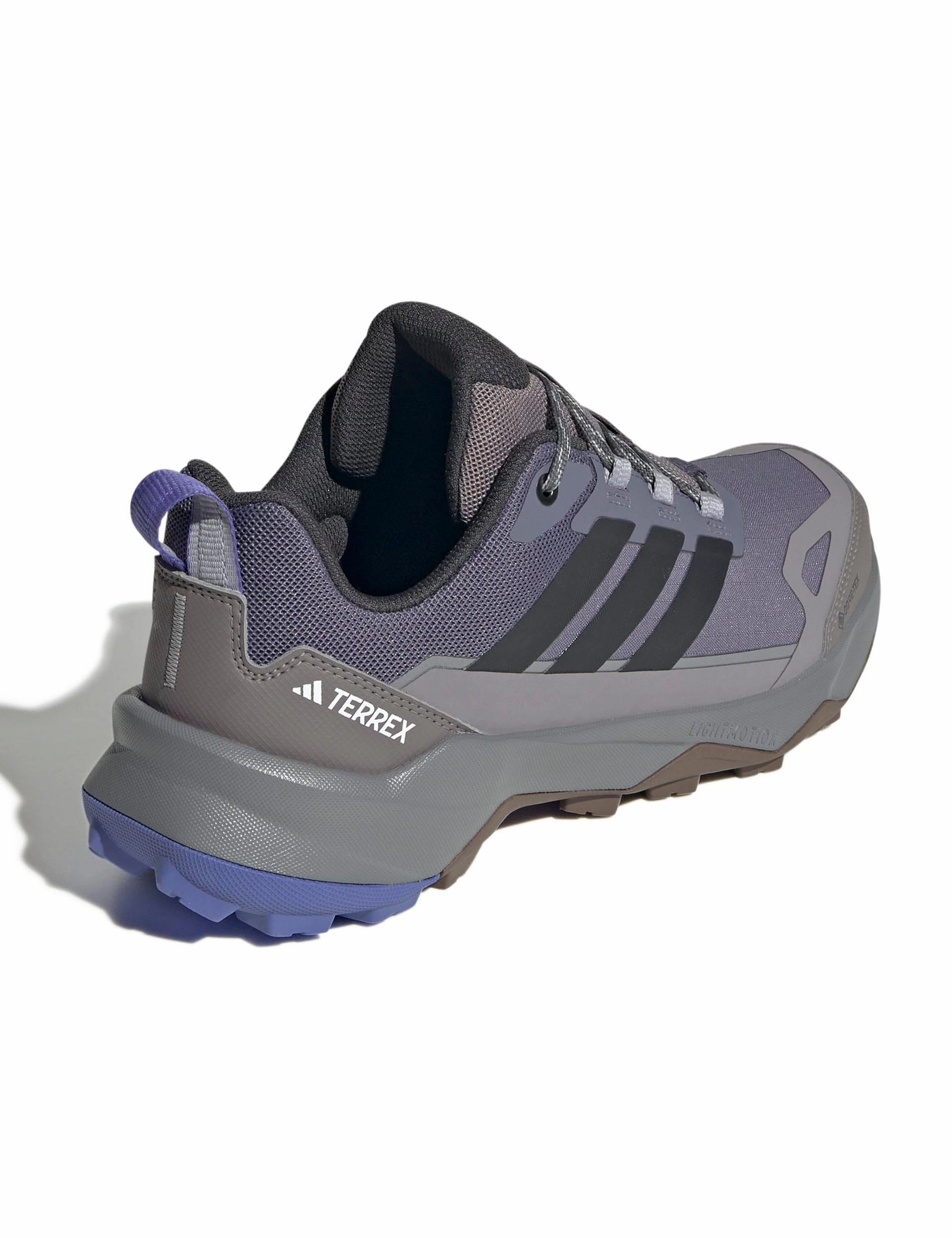 Terrex Skychaser AX5 GORE-TEX Hiking Shoes - Preloved Violet/Carbon/Taupe Oxide running in a stadium Odor Control Technology